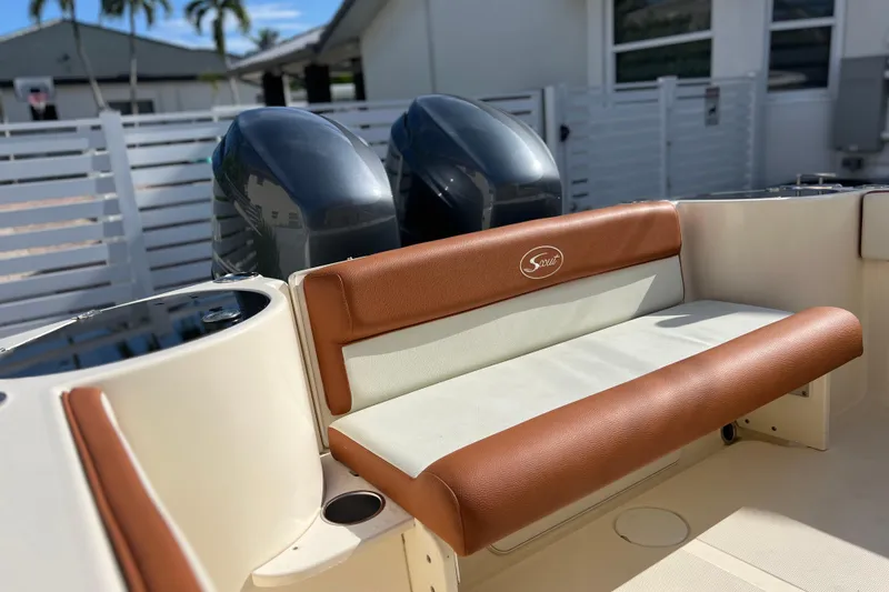 Slide: The Image of 2014 Scout 245 XSF boat with brown and white seating, dual engines, and outdoor setting. - 42