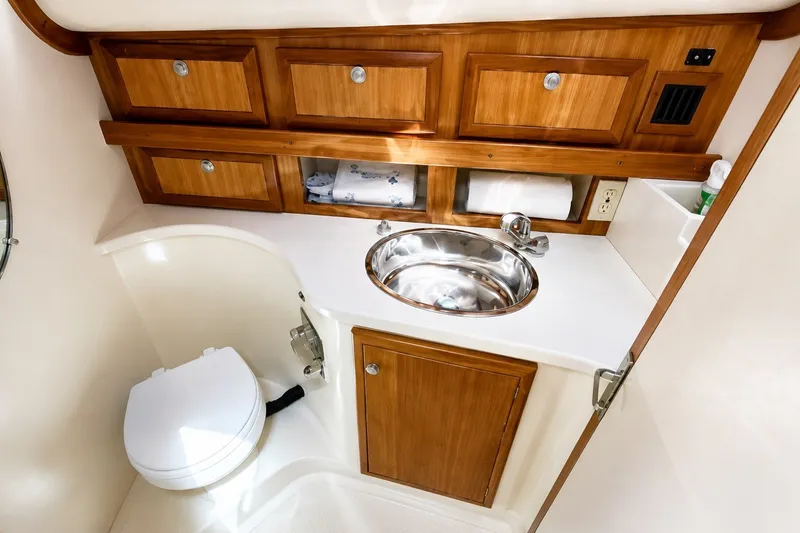 Slide: The Image of Luxurious 2005 Compton 33 Downeast Express boat bathroom with wood cabinetry and stainless steel sink. - 20