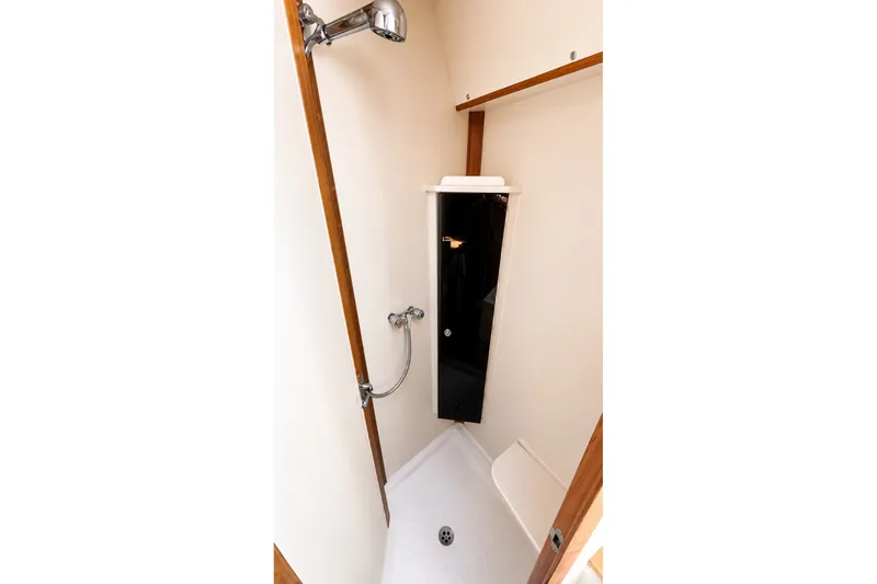 Slide: The Image of Shower area in 2005 Compton 33 Downeast Express boat, featuring wooden accents and modern fixtures. - 19