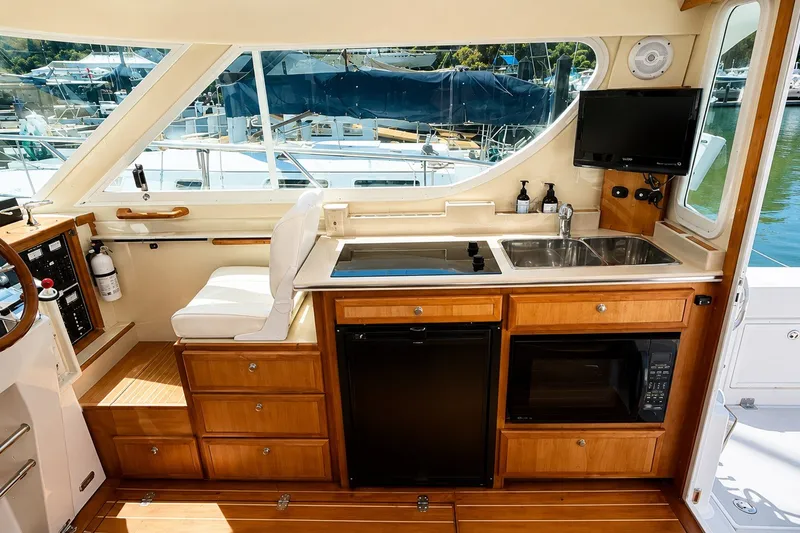 Slide: The Image of Interior of 2005 Compton 33 Downeast Express yacht with kitchenette and seating area. - 13