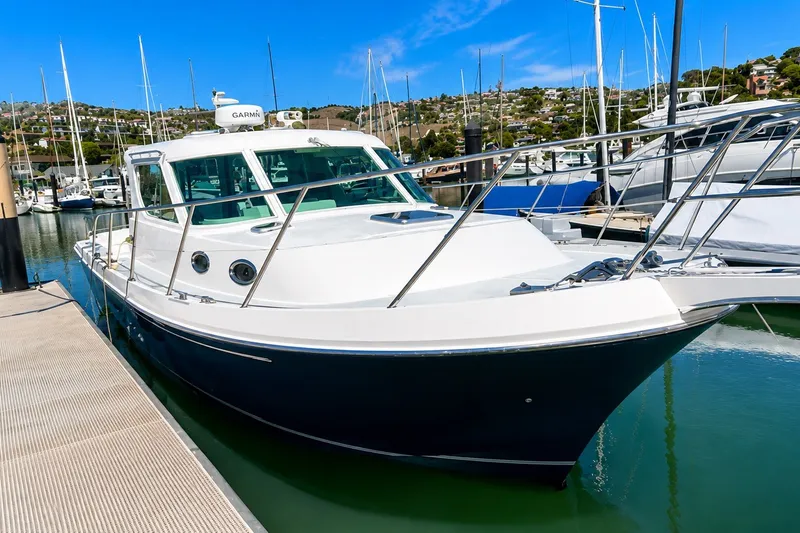 Slide: The Image of 2005 Compton 33 Downeast Express boat docked in a marina under clear blue skies. - 4