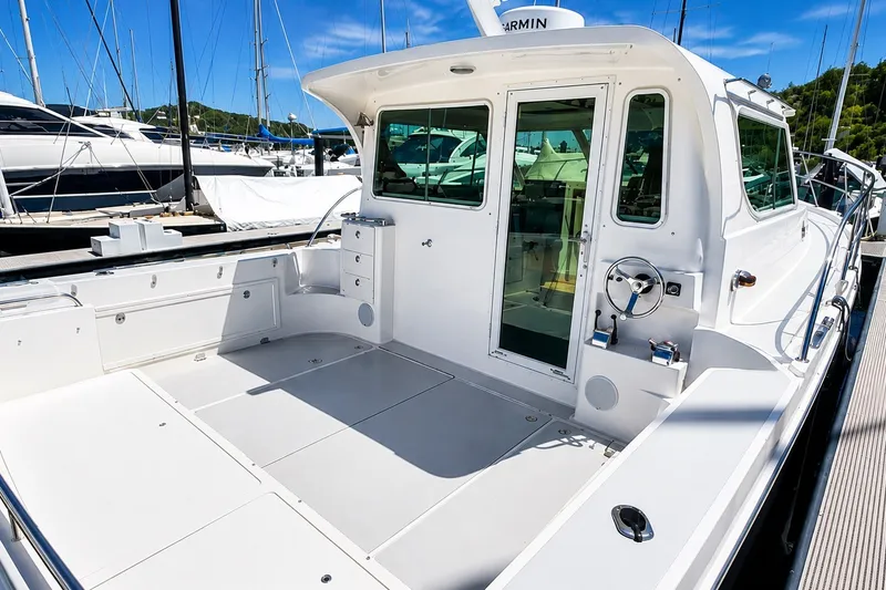Slide: The Image of 2005 Compton 33 Downeast Express boat with spacious deck and modern design. - 6