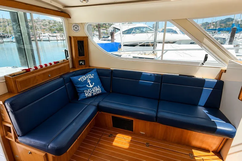 Slide: The Image of Interior of 2005 Compton 33 Downeast Express with blue seating and marina view. - 15