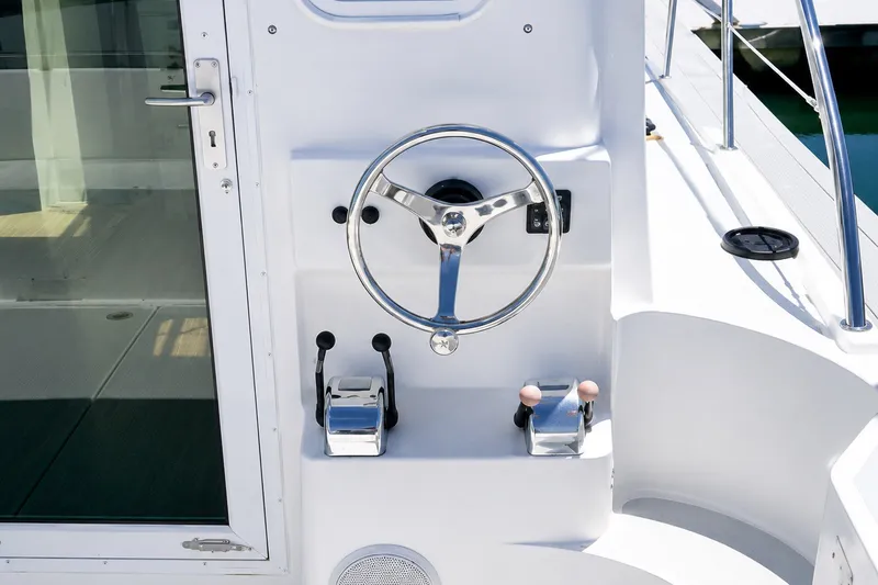 Slide: The Image of Steering console of a 2005 Compton 33 Downeast Express boat, featuring chrome controls. - 7