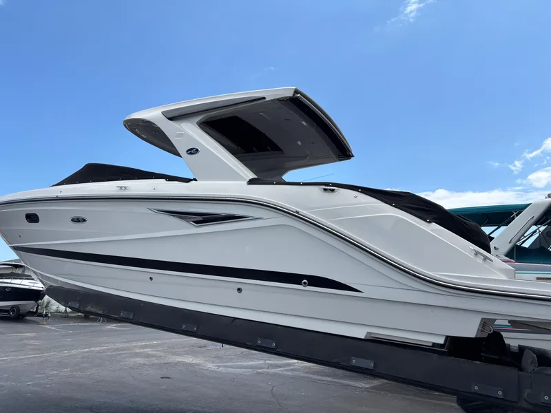 Slide: The Image of A sleek, modern boat with a curved design and protective canopy, resting on a trailer. - 1