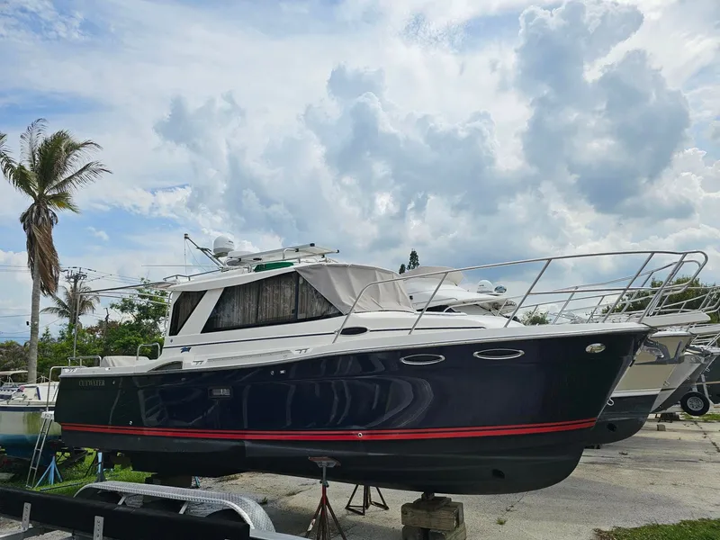 The Image of A 2021 Cutwater C-28 boat is on a dry dock under a cloudy sky. - 0