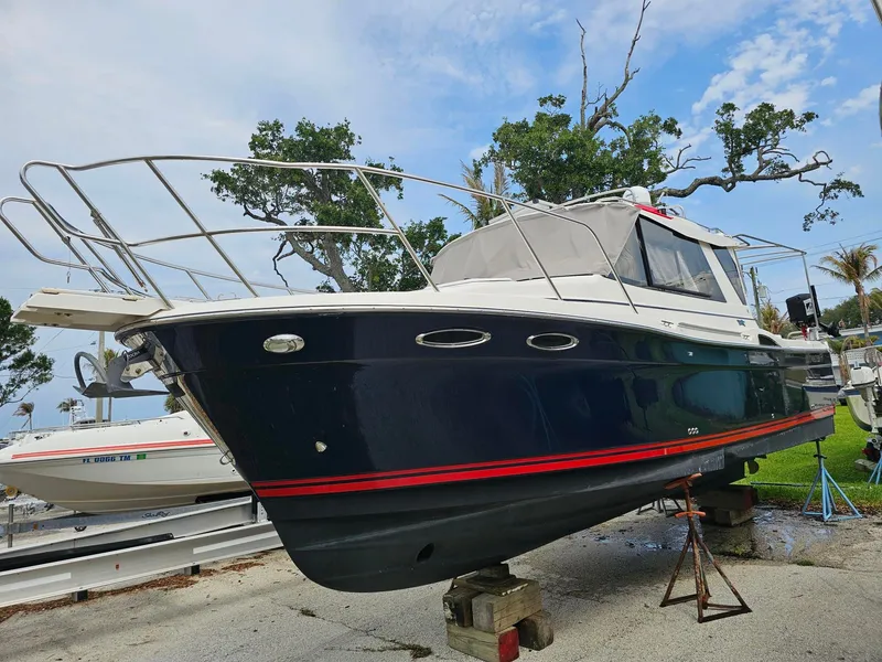 Slide: The Image of A 2021 Cutwater C-28 boat is on a stand. It features a dark blue hull. - 1