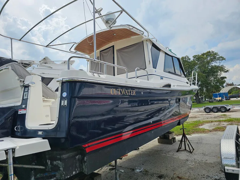Slide: The Image of A 2021 Cutwater C-28 boat is on land. It features a blue hull design with red accents. - 4