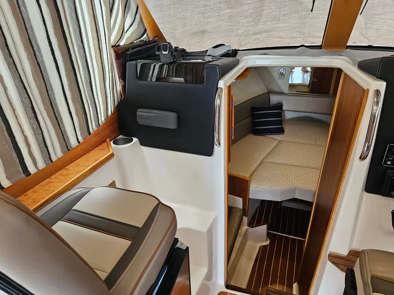 Slide: The Image of Interior of a 2021 Cutwater C-28 featuring a cozy cabin and striped curtains. - 17