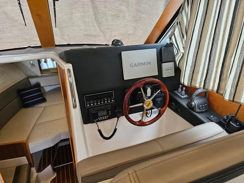 Slide: The Image of The cockpit of a 2021 Cutwater C-28 featuring a Garmin navigation system and a wooden steering wheel. - 15