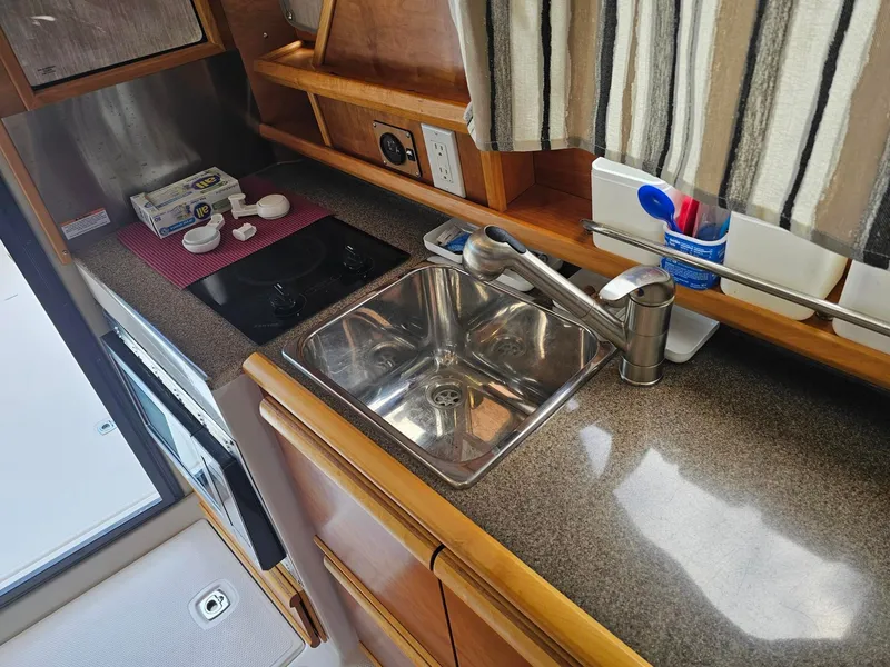 Slide: The Image of The galley of a 2021 Cutwater C-28 with a sink, stove, and countertop. - 19
