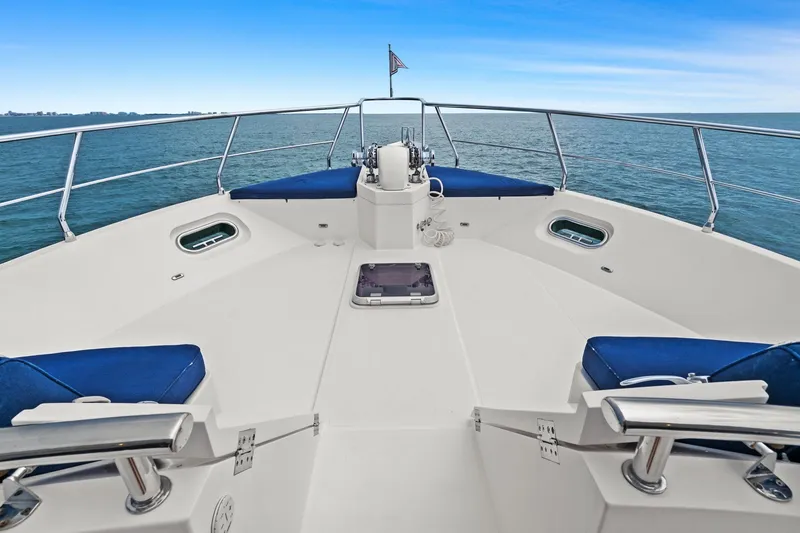 Slide: The Image of Bow view of 2015 Hampton Endurance yacht with blue cushions and ocean backdrop. - 83