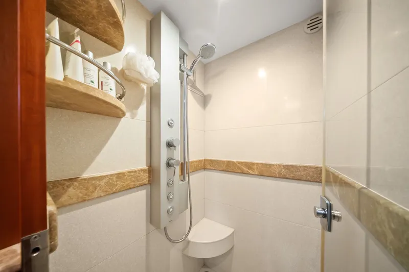 Slide: The Image of Modern shower in a 2015 Hampton Endurance yacht, featuring sleek fixtures and marble accents. - 38