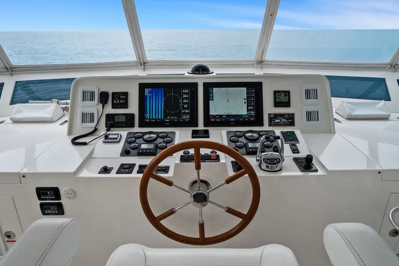 Slide: The Image of Helm of 2015 Hampton Endurance yacht with navigation screens and wooden steering wheel. - 66
