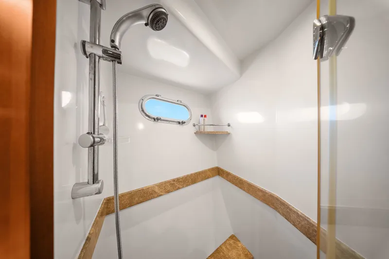 Slide: The Image of Luxurious shower in 2015 Hampton Endurance yacht with modern fixtures and porthole window. - 44