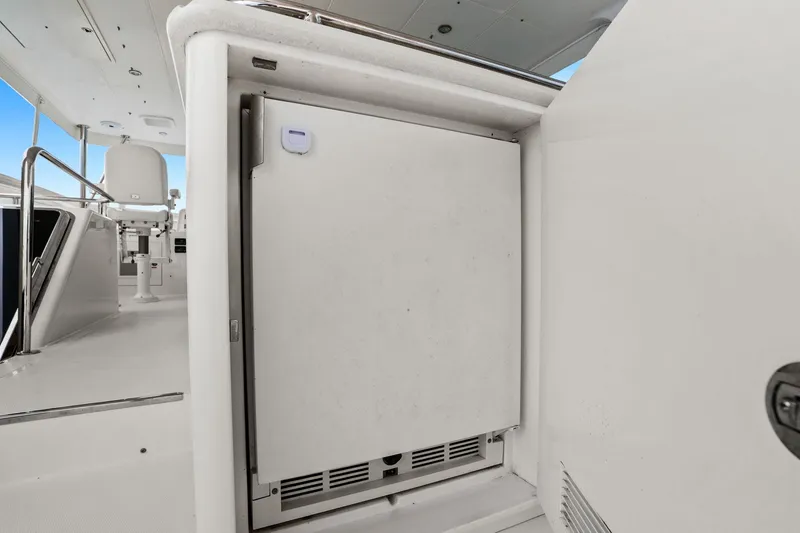 Slide: The Image of 2015 Hampton Endurance yacht interior with built-in refrigerator and seating area. - 74