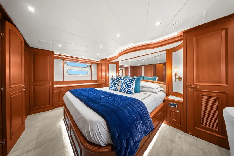 Slide: The Image of Luxurious 2015 Hampton Endurance yacht bedroom with elegant wood paneling and plush blue bedding. - 29