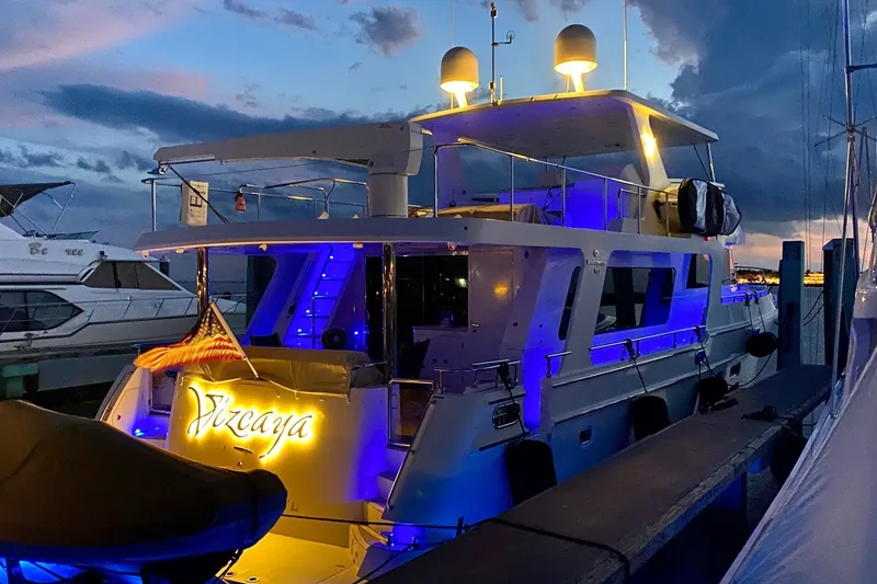 Slide: The Image of Luxurious 2015 Hampton Endurance yacht docked at sunset, illuminated with blue lights. - 6