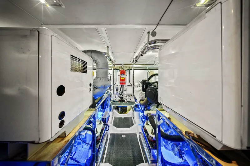 Slide: The Image of Engine room of a 2015 Hampton Endurance yacht, featuring modern equipment and blue lighting. - 61