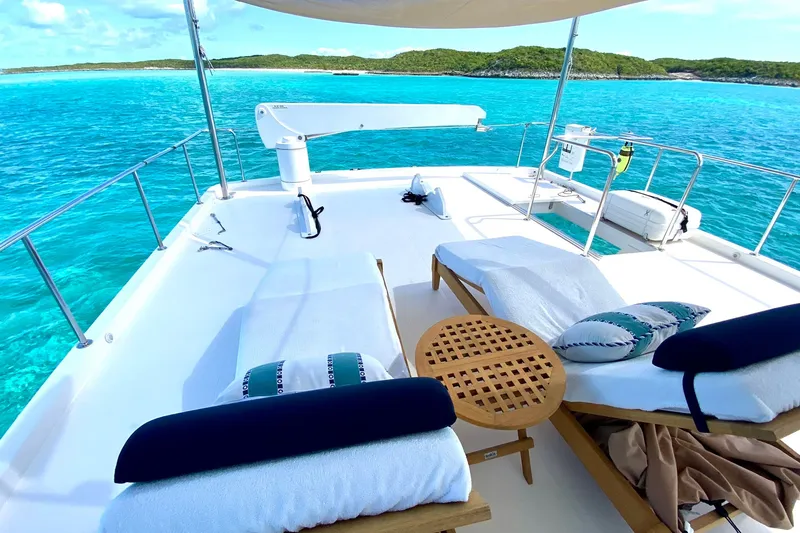 Slide: The Image of Luxurious 2015 Hampton Endurance yacht deck with sun loungers, turquoise sea, and scenic island view. - 75