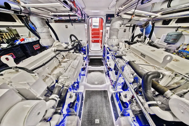 Slide: The Image of Engine room of a 2015 Hampton Endurance yacht, featuring dual engines and modern equipment. - 58