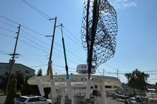 Slide: The Image of 2023 Bayliner 1703 Trophy boat with fishing gear, parked outdoors under clear sky. - 6