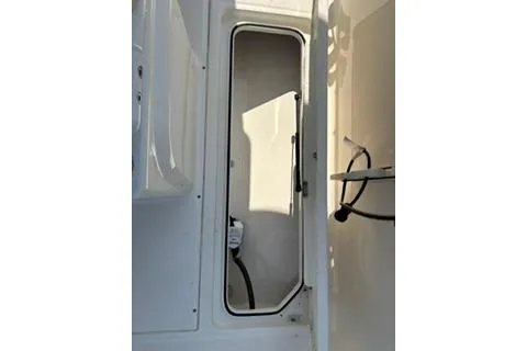 Slide: The Image of 2023 Bayliner 1703 Trophy boat storage compartment with open hatch and visible wiring. - 23