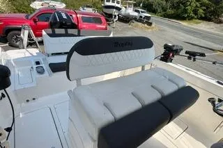 Slide: The Image of 2023 Bayliner 1703 Trophy boat interior with seating and controls, parked near red vehicles. - 8