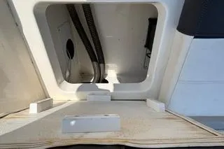 Slide: The Image of 2023 Bayliner 1703 Trophy boat storage compartment with open hatch and visible wiring. - 19