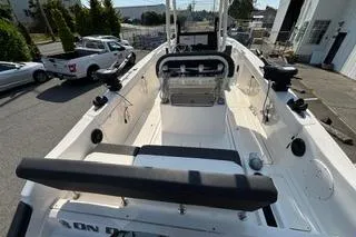 Slide: The Image of 2023 Bayliner 1703 Trophy boat interior, featuring seating and control console, parked outdoors. - 24