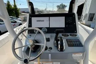Slide: The Image of 2023 Bayliner 1703 Trophy boat dashboard with steering wheel and Simrad navigation system. - 21