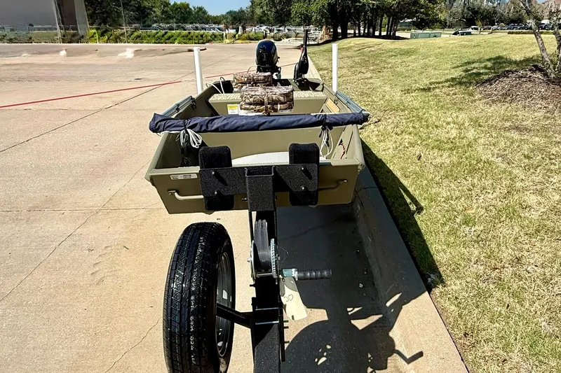 Slide: The Image of 2026 Tracker Grizzly 12 Jon boat on trailer, parked on a sunny day. - 3