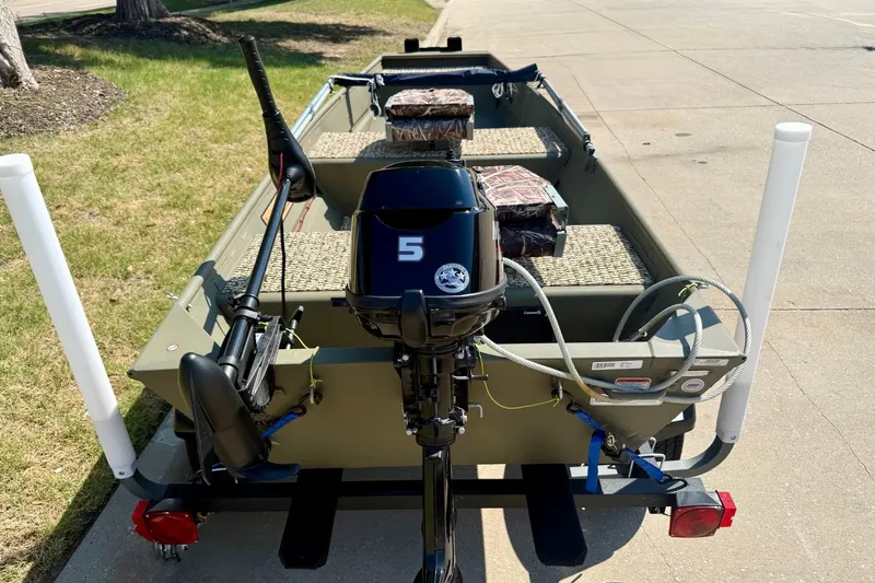Slide: The Image of 2026 Tracker Grizzly 12 Jon boat with motor, parked on pavement. - 2