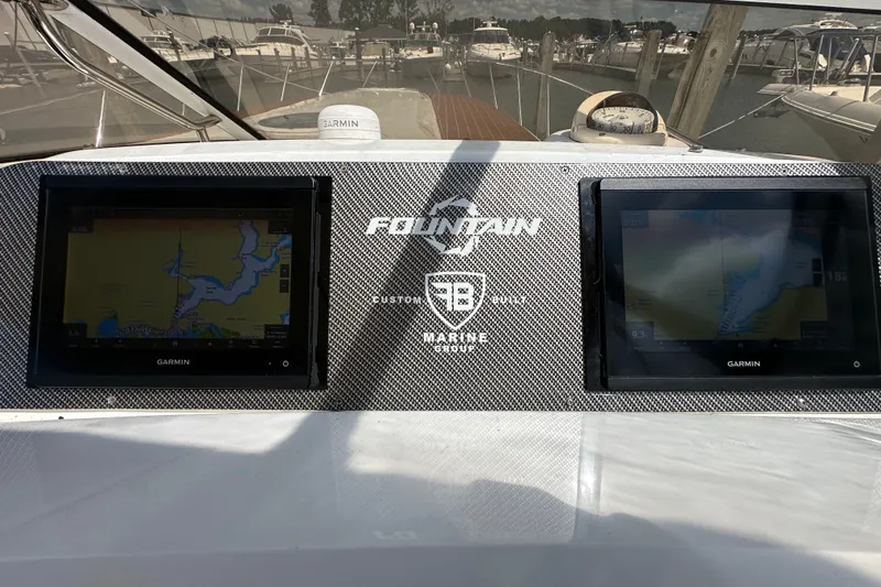 Slide: The Image of Dashboard of 2005 Fountain 48 Express Cruiser with dual Garmin displays at marina. - 21