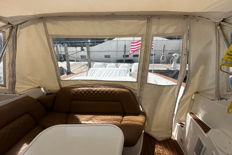 Slide: The Image of Interior view of 2005 Fountain 48 Express Cruiser with tan seating and dockside view. - 37