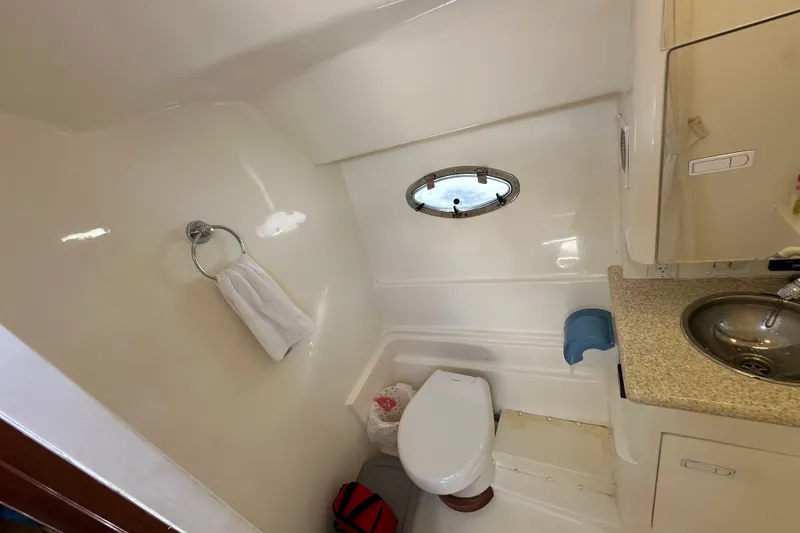 Slide: The Image of 2005 Fountain 48 Express Cruiser bathroom with sink, toilet, and porthole window. - 34