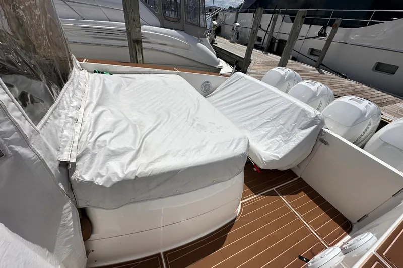 Slide: The Image of 2005 Fountain 48 Express Cruiser with covered deck and outboard engines at marina. - 38