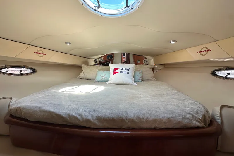 Slide: The Image of Luxurious cabin interior of 2005 Fountain 48 Express Cruiser with cozy bedding and porthole windows. - 29