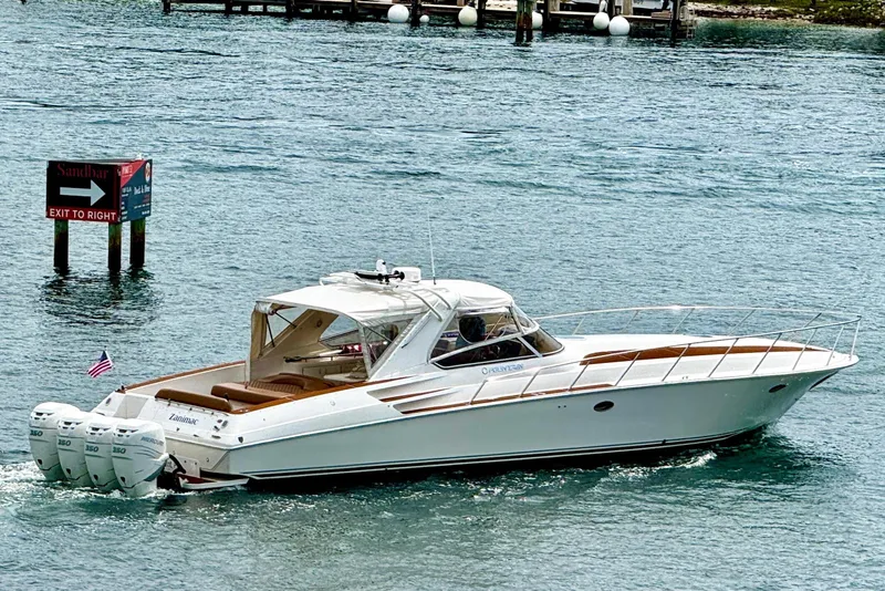 The Image of A white 2005 Fountain 48 Express Cruiser on calm water, featuring three outboard engines. - 0