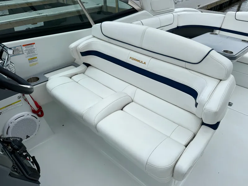 Slide: The Image of The image shows a white bench seat with blue accents on a boat, surrounded by additional seating. - 20