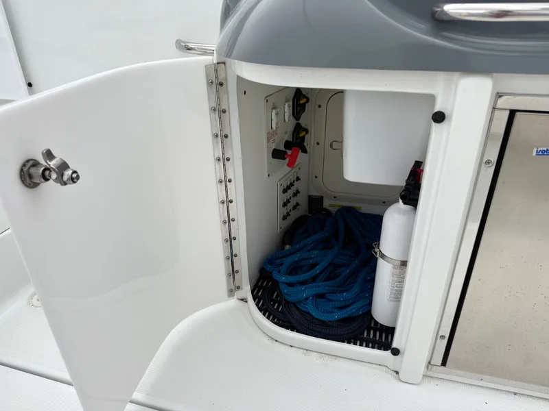 Slide: The Image of An open storage compartment on a boat reveals ropes and a fire extinguisher. - 11
