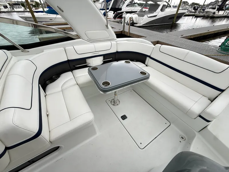 Slide: The Image of The image shows the cockpit of a 2014 Formula 350 Crossover Bowrider with white upholstery and a table. - 4