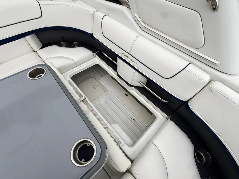 Slide: The Image of The image shows a boat seating area with white upholstery and a table with cup holders. - 6