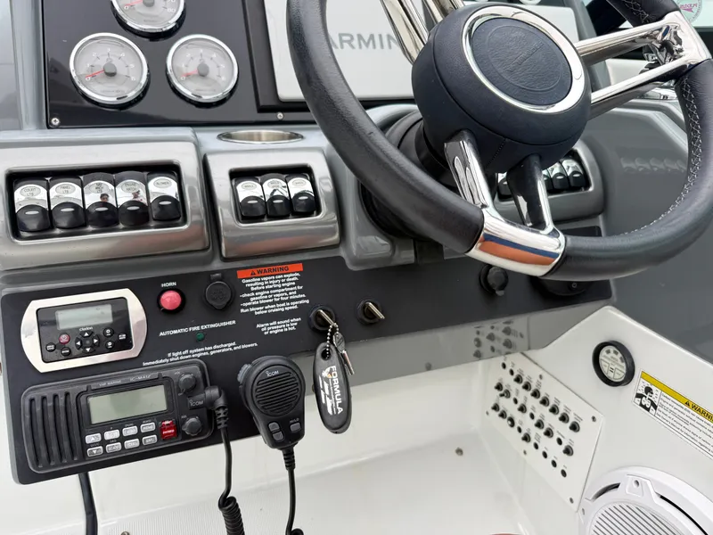 Slide: The Image of The image shows a boat's helm with a steering wheel, gauges, and communication devices. - 19