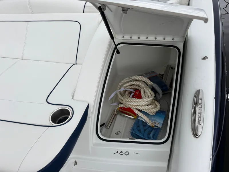 Slide: The Image of An open storage compartment on a boat with ropes and accessories. White upholstery is visible. - 3
