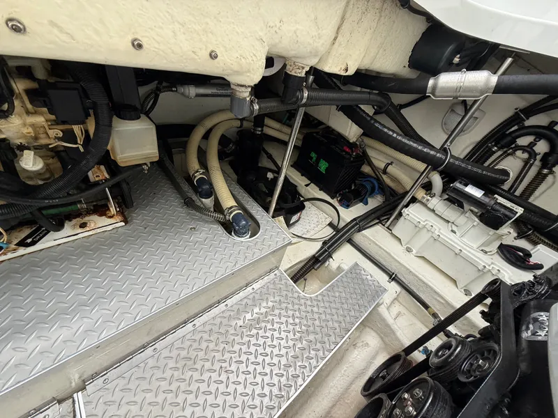 Slide: The Image of The engine compartment of a boat features metal flooring, hoses, and various mechanical components. - 45
