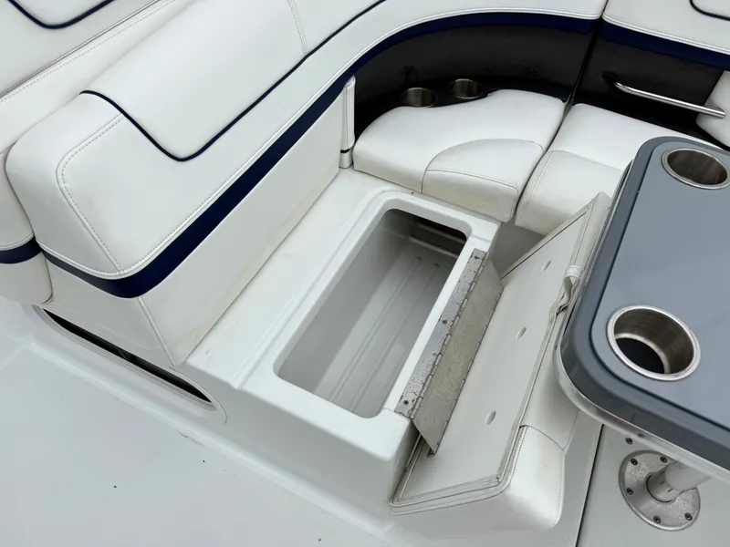 Slide: The Image of A white seating area with an open storage compartment and a table with cup holders. - 7