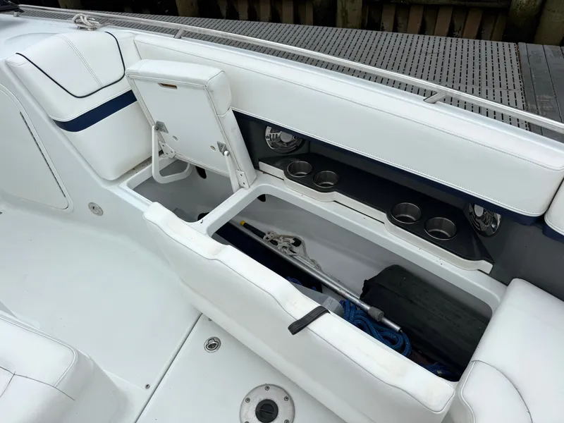Slide: The Image of The image shows a boat seating area with white upholstery and an open storage compartment. - 33