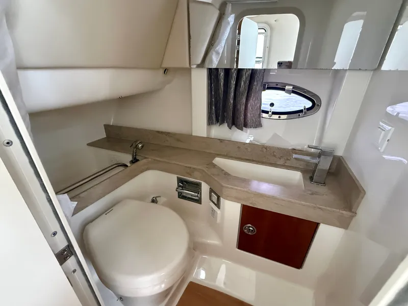 Slide: The Image of The image shows a sleek boat bathroom with a sink, toilet, and porthole. - 29