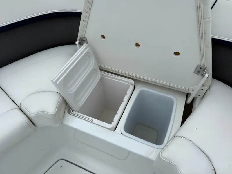 Slide: The Image of An open storage compartment with two sections on a boat with white upholstery. - 35